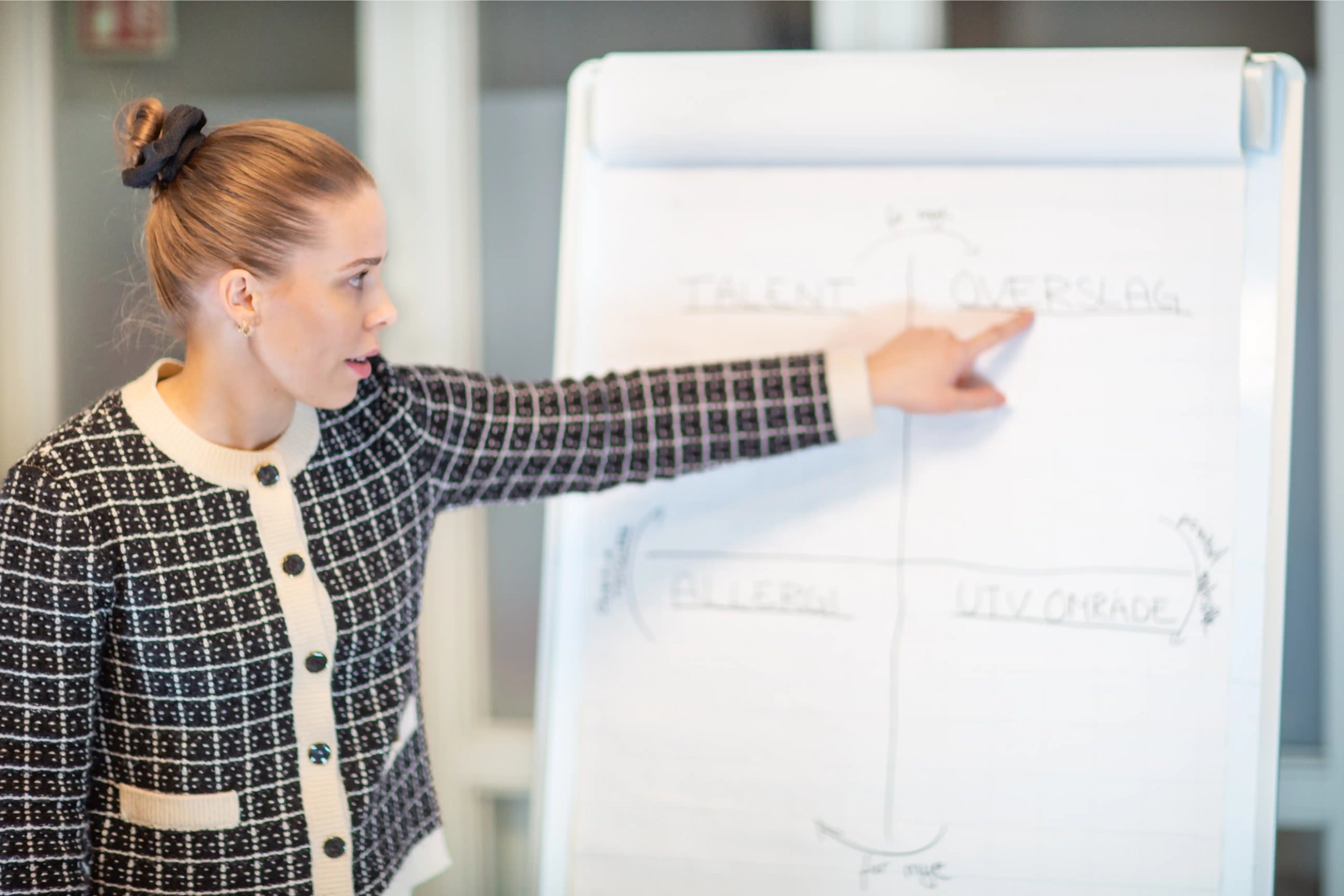 Kvinnelig terapeut forklarer modell på tavle i undervisning