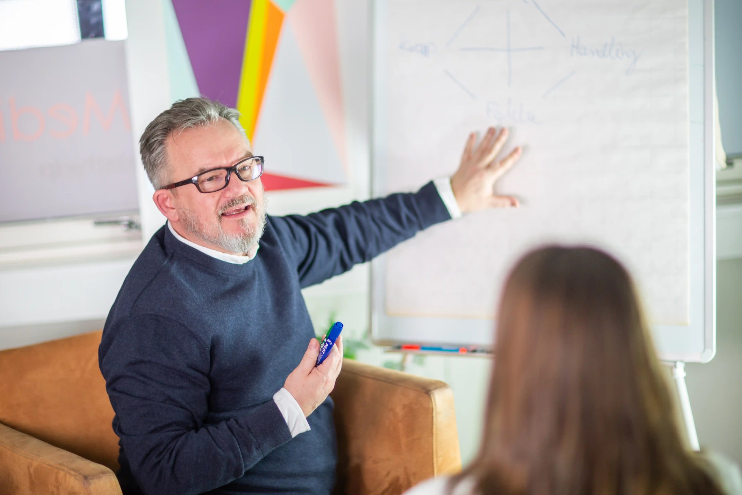Terapeut peker på tavle under veiledning